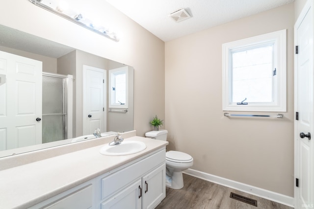 full bathroom with a wealth of natural light, visible vents, a shower stall, and vanity