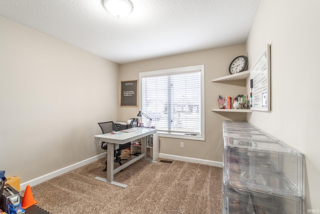 carpeted office with visible vents, baseboards, and a textured ceiling