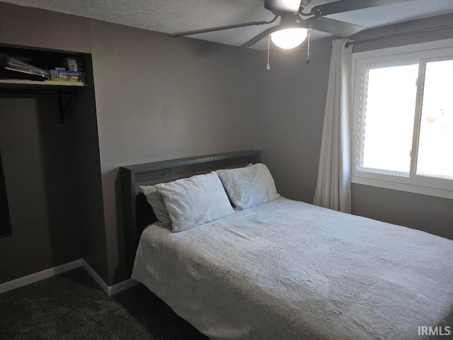 bedroom with dark colored carpet, a ceiling fan, and baseboards