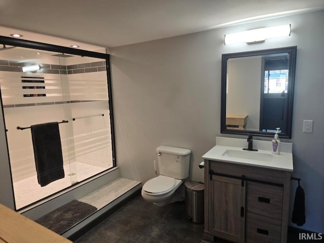 bathroom featuring vanity, a shower stall, and toilet