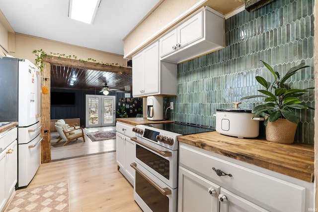 kitchen featuring butcher block counters, light wood-type flooring, white appliances, and white cabinets