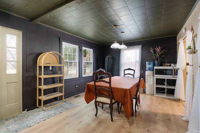 dining room featuring wood finished floors, visible vents, and crown molding