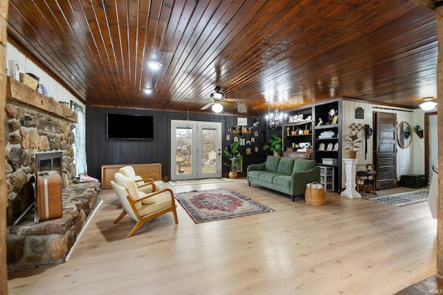 living area with ceiling fan, a fireplace, wooden ceiling, and wood finished floors