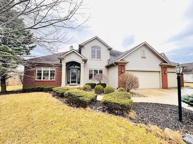 view of front of home featuring driveway, brick siding, a chimney, an attached garage, and a front yard