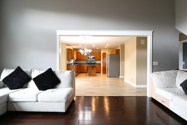 living room with light wood-type flooring, baseboards, a chandelier, and recessed lighting