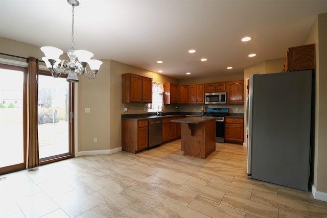 kitchen featuring dark countertops, a center island, stainless steel appliances, a sink, and recessed lighting