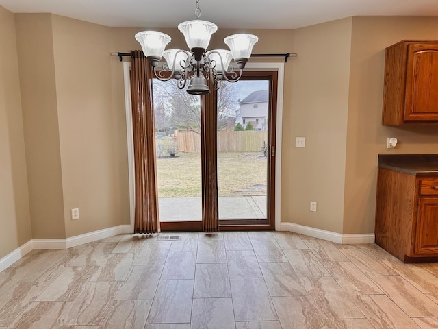 doorway to outside featuring an inviting chandelier, visible vents, and baseboards