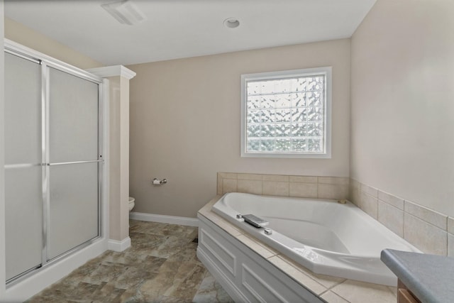 bathroom with toilet, a stall shower, baseboards, and a garden tub