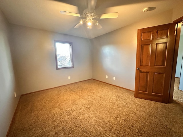 empty room with a ceiling fan, carpet, and baseboards