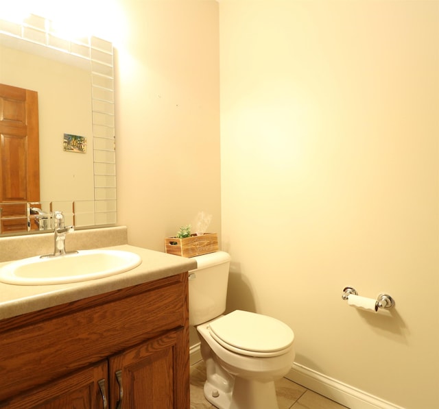 half bathroom with vanity, toilet, and tile patterned floors