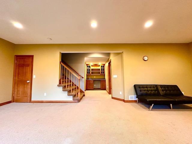 sitting room featuring carpet floors, stairway, baseboards, and visible vents