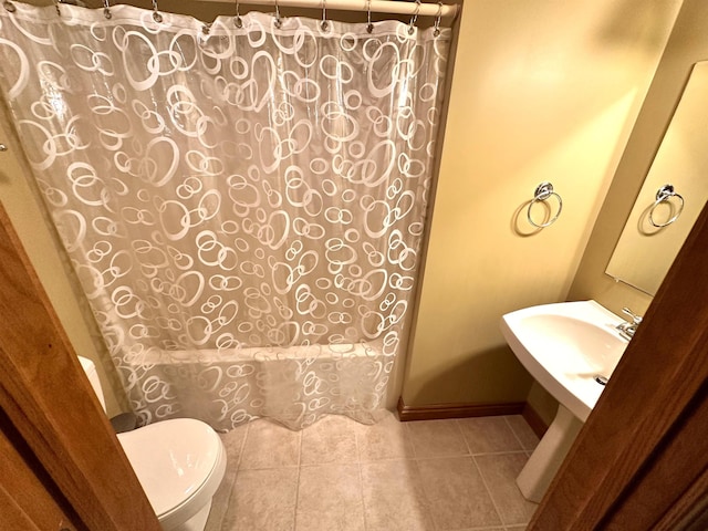 full bathroom with toilet, shower / tub combo with curtain, a sink, and tile patterned floors