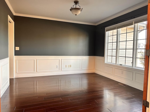 empty room featuring ornamental molding, dark wood-type flooring, visible vents, and a healthy amount of sunlight