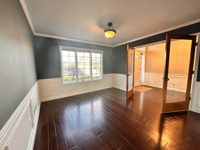 spare room featuring visible vents, ornamental molding, dark wood-style flooring, and french doors