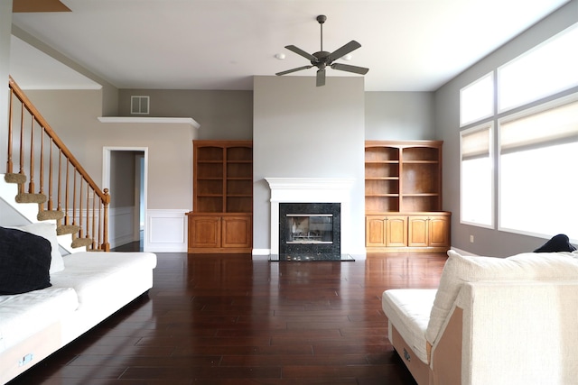 unfurnished living room featuring a wealth of natural light, visible vents, a fireplace, and wood finished floors