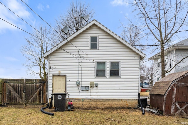 rear view of house with an outbuilding, fence, and a shed