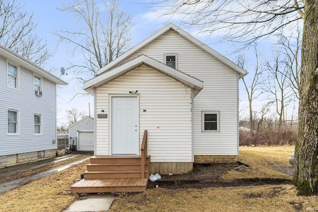 rear view of house featuring entry steps and an outdoor structure