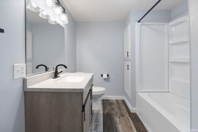 full bath featuring baseboards, toilet, wood finished floors, vanity, and shower / washtub combination