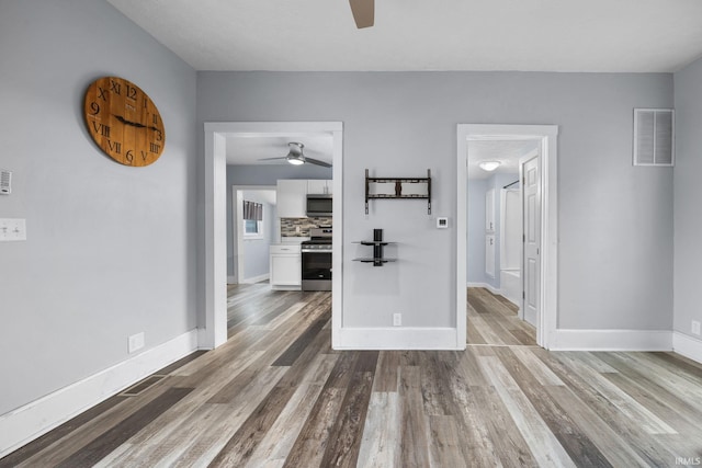 interior space featuring visible vents, baseboards, and wood finished floors