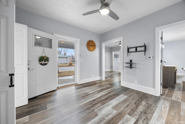 foyer entrance featuring ceiling fan, wood finished floors, and baseboards