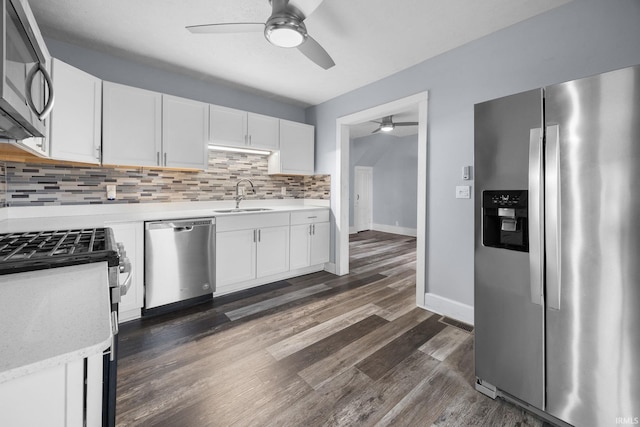 kitchen featuring dark wood-style floors, tasteful backsplash, appliances with stainless steel finishes, white cabinetry, and a sink