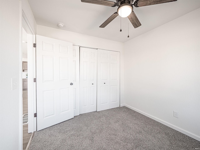 unfurnished bedroom featuring carpet, baseboards, ceiling fan, and a closet