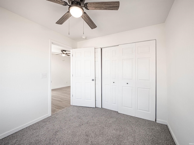 unfurnished bedroom featuring carpet floors, a closet, baseboards, and a ceiling fan