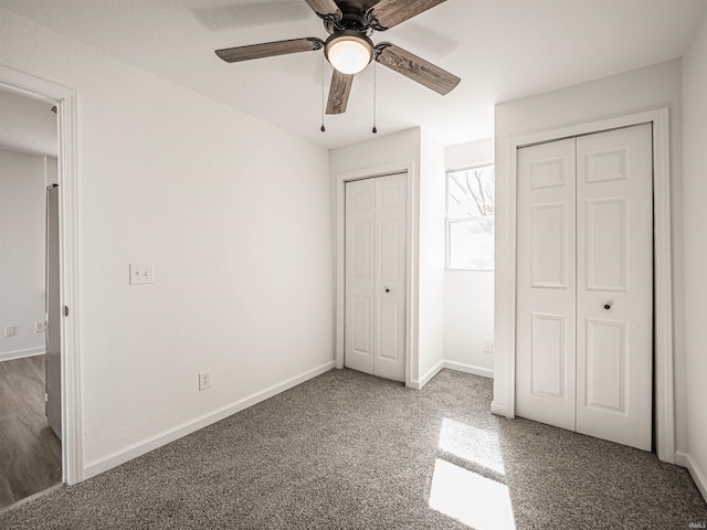 unfurnished bedroom featuring baseboards, ceiling fan, carpet, and multiple closets