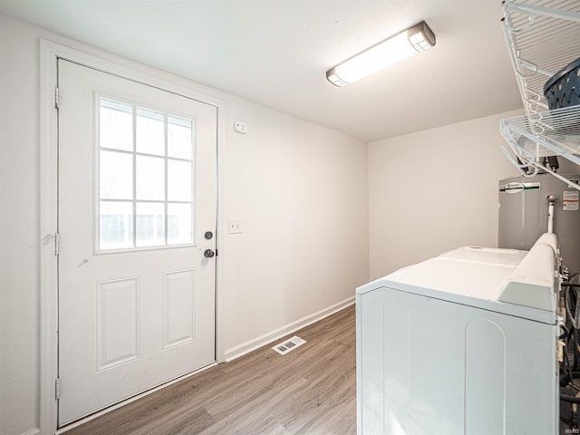 laundry area featuring laundry area, visible vents, baseboards, light wood-type flooring, and separate washer and dryer