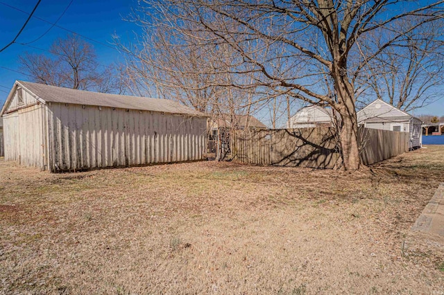 view of yard with an outbuilding and fence