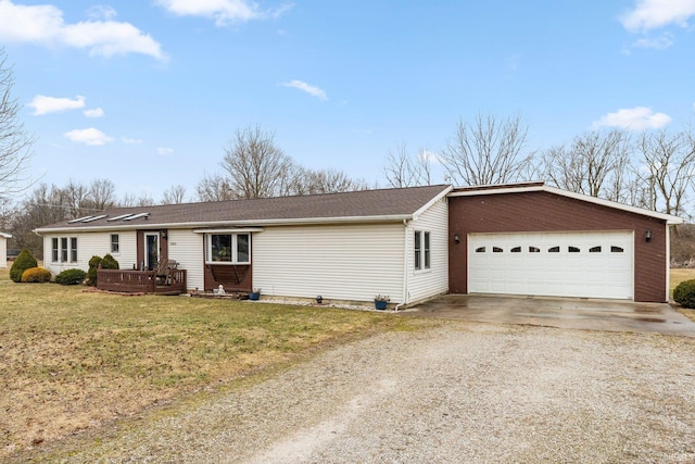 ranch-style house featuring an attached garage, driveway, a wooden deck, and a front lawn