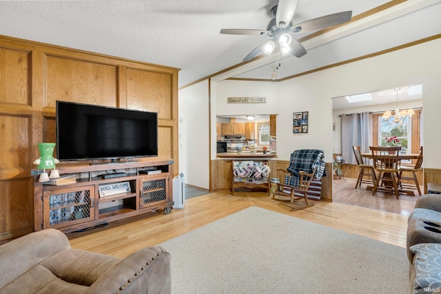 living room with a textured ceiling, light wood finished floors, lofted ceiling, and a ceiling fan