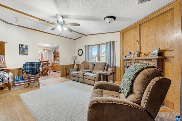 living area featuring a textured ceiling, wainscoting, and wooden walls