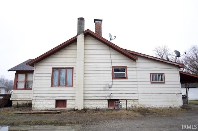 view of side of home featuring a carport and a chimney