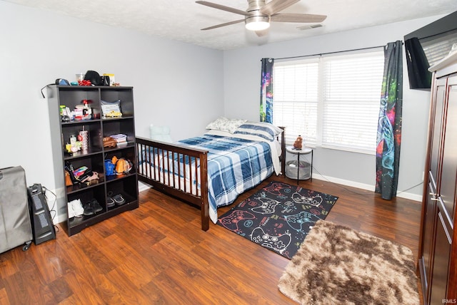 bedroom with baseboards, visible vents, a ceiling fan, wood finished floors, and a textured ceiling