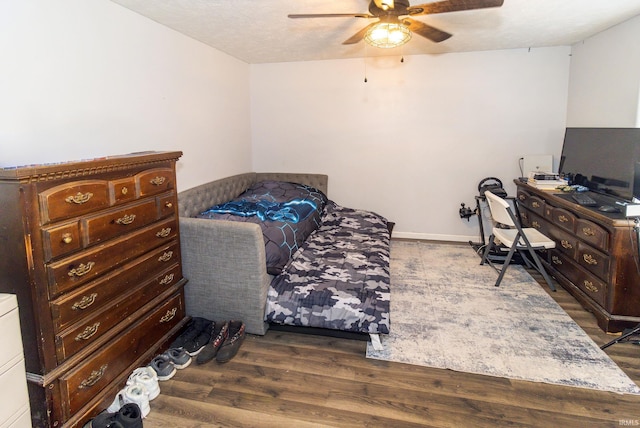 bedroom featuring dark wood-style floors, ceiling fan, a textured ceiling, and baseboards