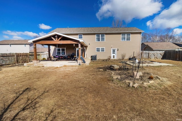 rear view of house featuring a fenced backyard, cooling unit, a patio, and a gazebo