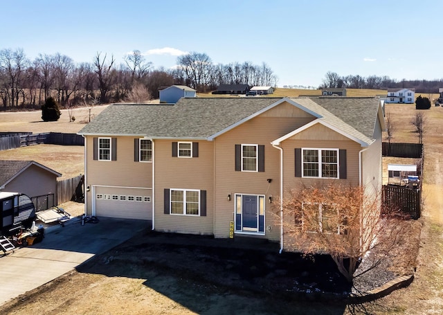 view of front facade with a garage, driveway, a shingled roof, and fence