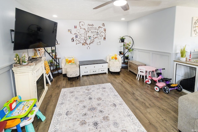 rec room featuring recessed lighting, a decorative wall, wainscoting, ceiling fan, and wood finished floors