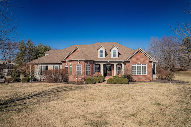 view of front of home featuring brick siding and a front lawn