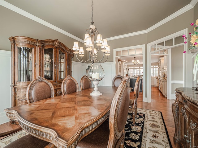 dining room featuring a chandelier, ornamental molding, and light wood-style flooring