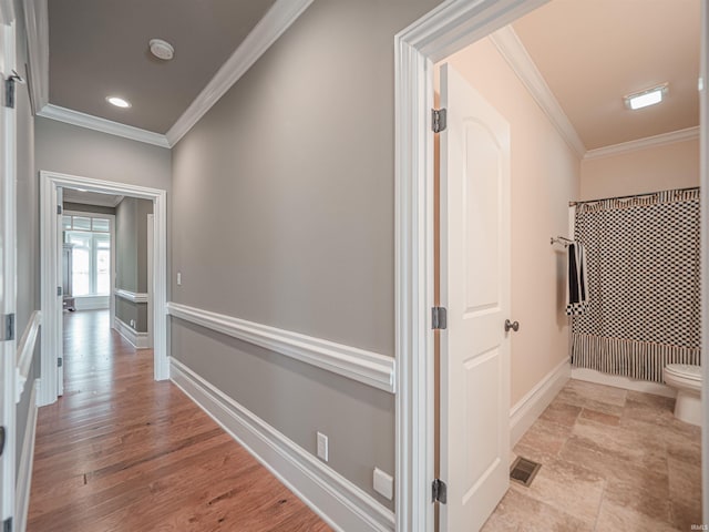 hallway with recessed lighting, visible vents, baseboards, light wood finished floors, and crown molding