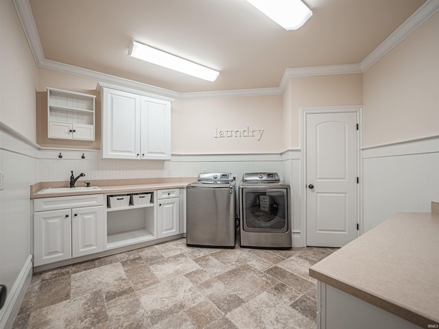 laundry room with wainscoting, a sink, cabinet space, and washer and dryer