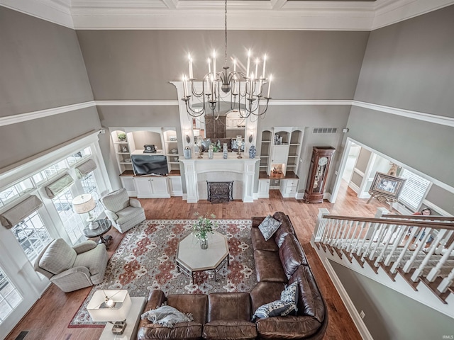 living room featuring arched walkways, a fireplace, a towering ceiling, and wood finished floors