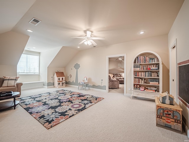 living area with lofted ceiling, built in shelves, carpet floors, visible vents, and a ceiling fan