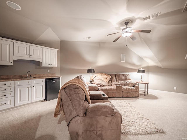 living area with baseboards, visible vents, light colored carpet, lofted ceiling, and ceiling fan