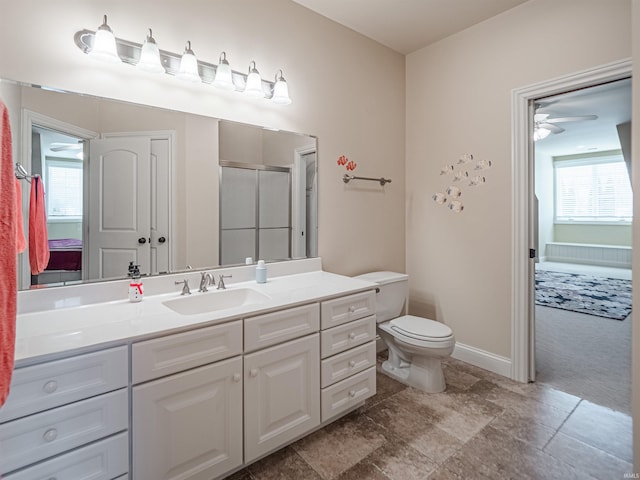 bathroom with ceiling fan, toilet, vanity, baseboards, and a shower stall