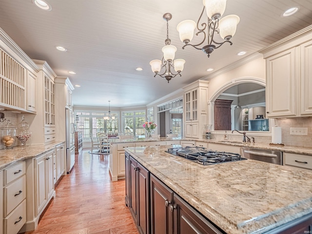 kitchen featuring gas stovetop, dishwasher, crown molding, and a notable chandelier