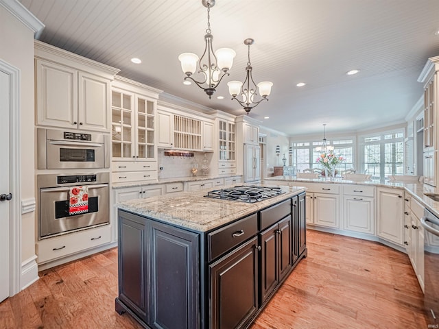 kitchen featuring white cabinetry, appliances with stainless steel finishes, a chandelier, and crown molding