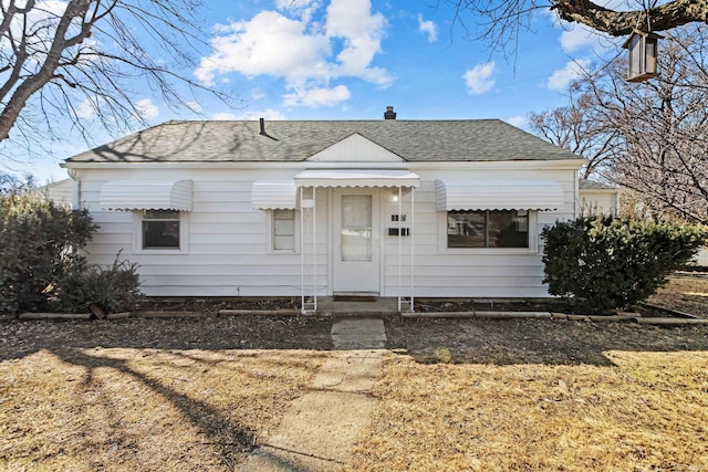 bungalow-style home with roof with shingles